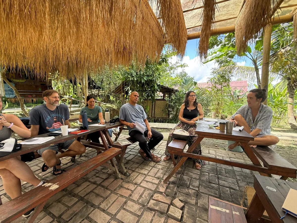 Adults learning together under a thatched pavilion at Empathy School Bali