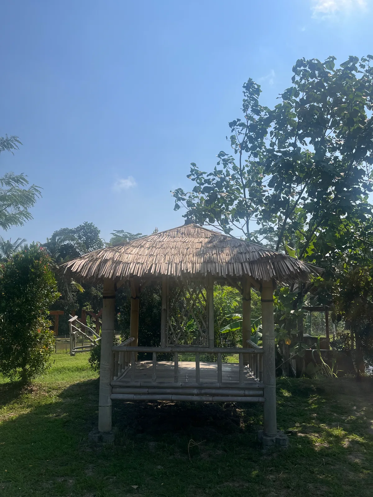 A thatched bale bengong pavilion in the gardens of Empathy School Bali