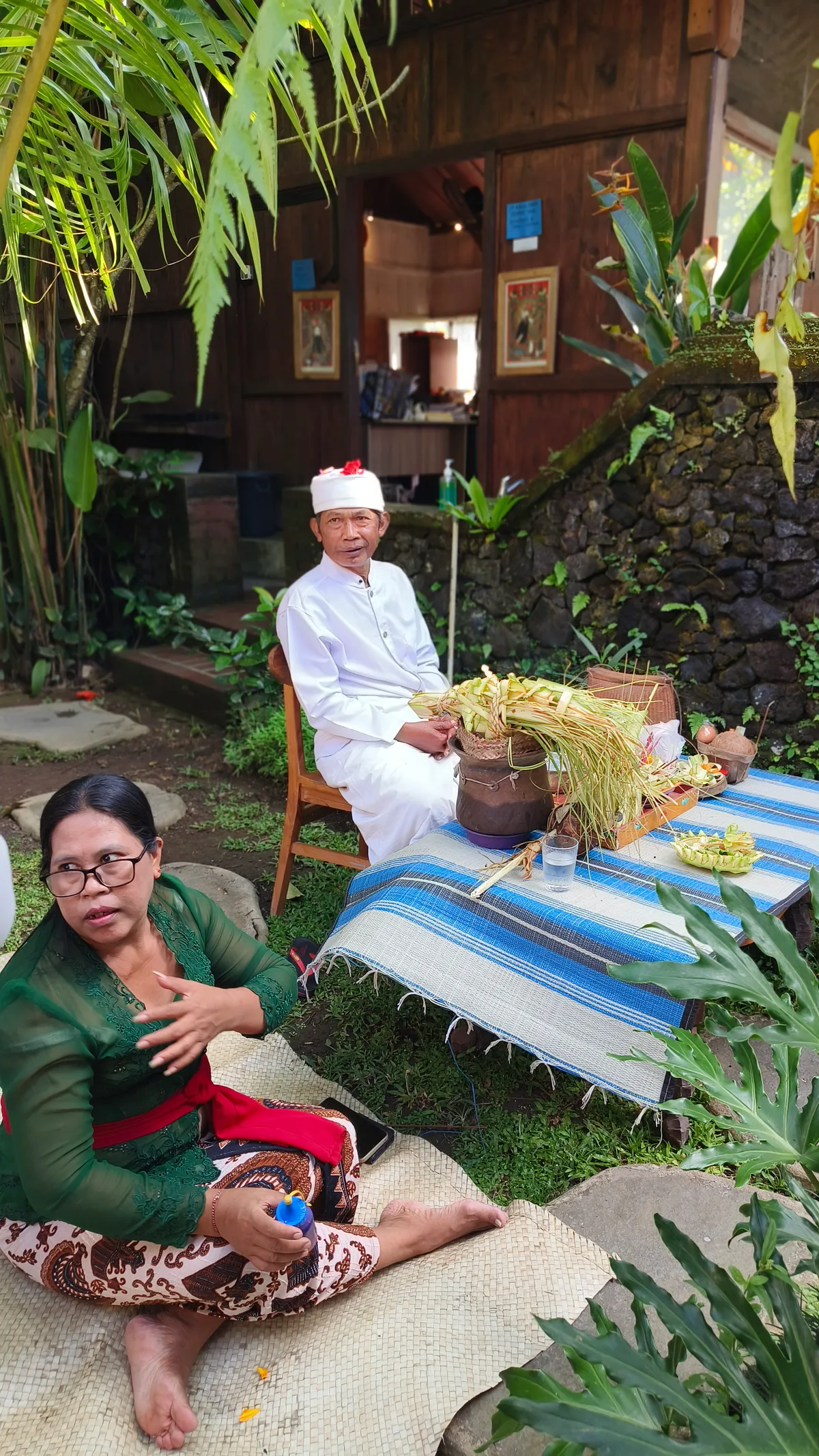 People preparing an offering beside a temple at Empathy School Bali